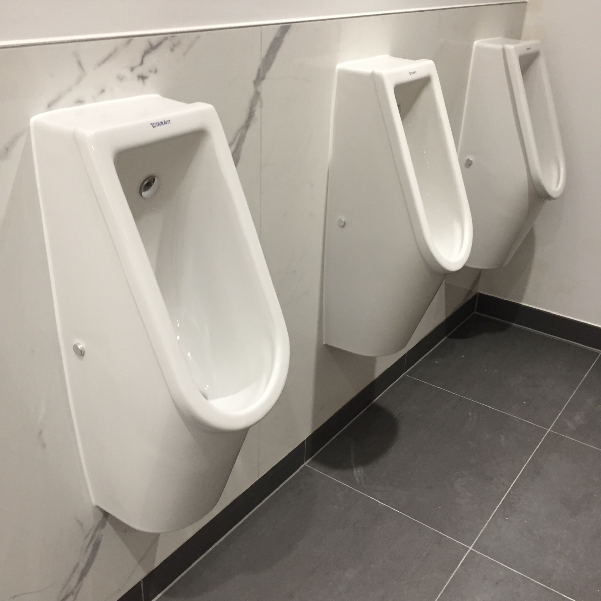 three urinals with a white mastic applied
