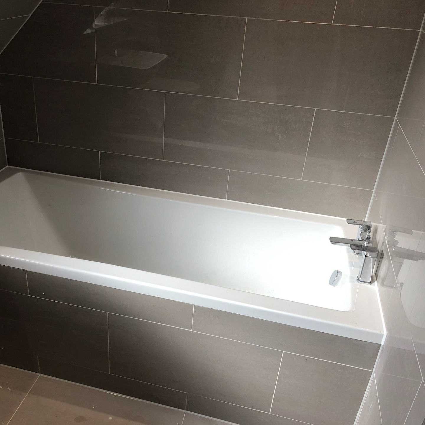 Bath with white mastic around horizontal and vertical joins