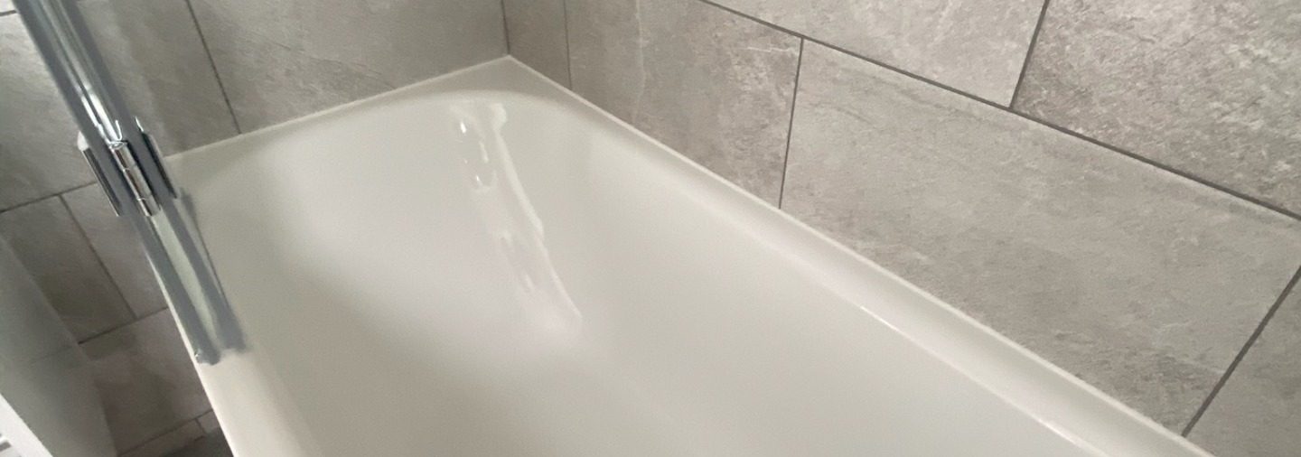 bathtub with white silicone around edge