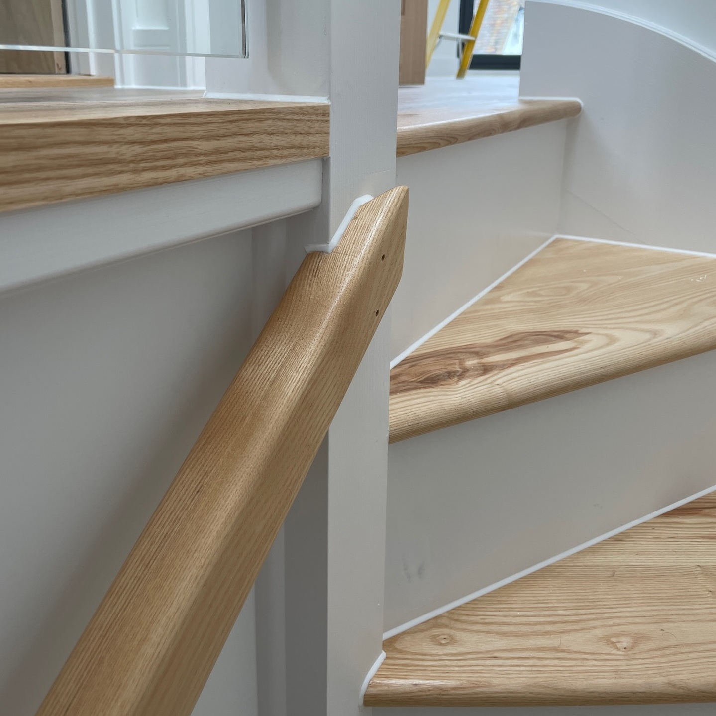 white silicone applied to stair joins and hand rail